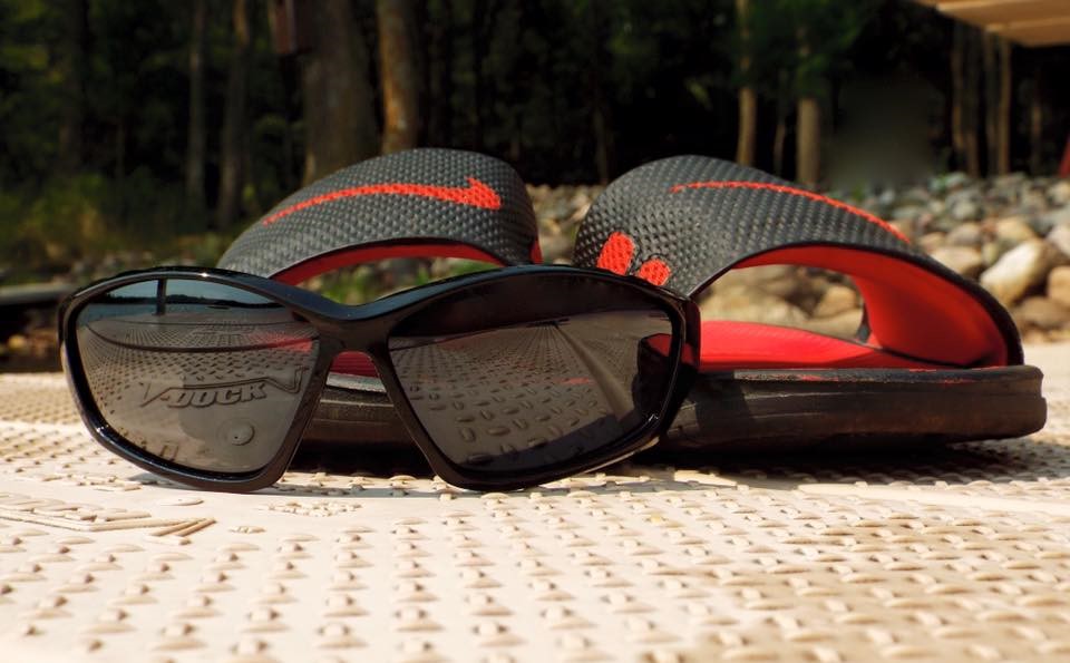 A pair of sunglasses and sandals sitting on a dock